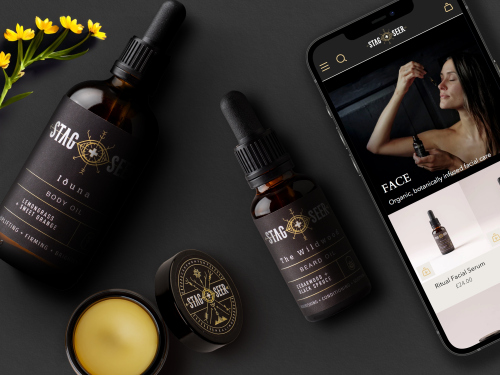 Two bottles of face oil, a jar of balm and an iPhone laying on black card. displayed to showcase new packaging design and website design for Stag + Seer Start brand.